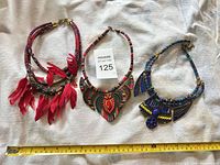 All three necklaces with measuring tape for scale