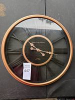 Front view of round wall clock showing brand and dial