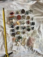 Full lot with measuring tape showing cups of stones, carved pieces, bracelets and bags