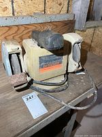 Front view of Black & Decker 5-inch bench grinder showing label, wheels, cord