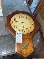 Front view of wooden wall clock showing entire case and dial