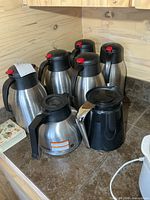 Group view of seven coffee carafes on countertop