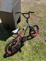 Full view of child’s red bike with black chain guard and red wheels