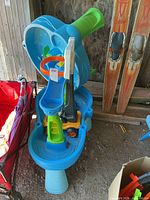 Stacked blue plastic water tables and basketball net