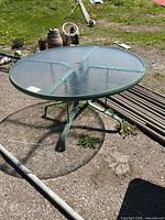 overall view of round glass patio table on metal frame outdoors