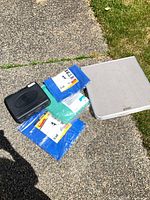 Lot overview showing stove case, packaged tarps, folded table top
