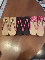 All three pairs side-by-side on table showing soles and straps
