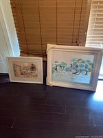 Both framed prints: large crane scene and smaller cottage scene