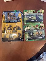 All three packaged items laid out: LOTR Combat Hex Starter Set and two Ben 10 2-packs