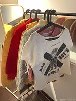 Group of five garments on rack showing colors and styles