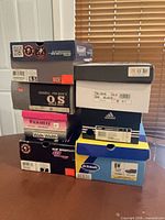 Stack of eight shoe boxes showing various brands and sizes