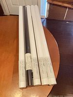 Five sealed art paper rolls on table