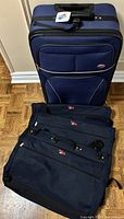 Suitcase front view with three garment bags