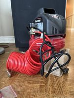 Full view of Powermate compressor with coiled hose and cords