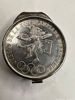Front view showing Aztec figure, Olympic rings and inscription