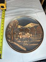 Full view of round carved wood plaque with measuring tape showing ~14 in diameter