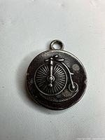 Front of sterling silver pendant showing penny-farthing design