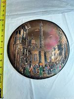 Full view of round copper plate with Middle Eastern scene, tape measure showing roughly 15 inches