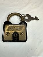 Front view of DeLuxe padlock with key attached