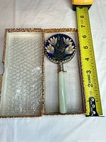 Mirror in open fitted case alongside measuring tape showing length