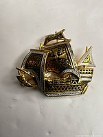front view of gold and silver-tone sailing ship brooch