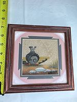 Full view of framed sand art with measuring tape showing size