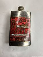 Front view of Paragon pocket lighter showing red enamel Boston Breakfast Coffee advertisement