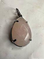 Front view of faceted rose quartz teardrop pendant with prong and bezel setting