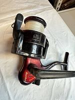 Left side view of South Bend Competitor 670A spinning reel showing Long Cast spool with line and red body