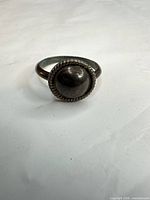 Front view of sterling silver domed ring with rope border