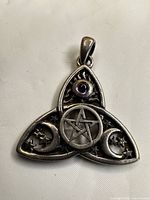 front view of pendant showing amethyst, pentagram, moons and stars