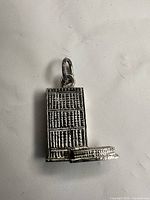Front view of sterling silver bookshelf pendant charm showing book details and bail