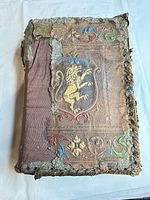 Front cover showing detached leather decorative board with cloth spine
