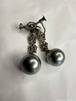 Full view of both earrings showing faux pearls and screw backs