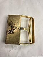 Front view of brass buckle with raised Mickey Mouse design
