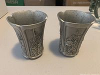 Front view of both cups showing relief panels and scalloped rims