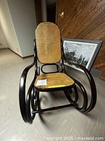 Front view of rocking chair showing cane seat and back