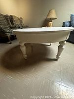Full view of white round coffee table showing legs and finish