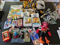 Overview of entire lot showing Lego pieces, book, plush, novelty items and carded figures