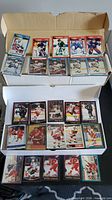 Two open card storage boxes with rows of 1990s hockey cards, some sleeved