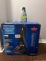 Boxed Bissell StainPro unit with detergent bottle on top
