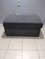 Front view of gray fabric storage ottoman closed