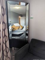Front view of full-length beveled mirror leaning against wall