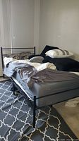 Full view of assembled black metal bed frame and mattress