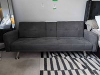 Front view of charcoal gray microfiber futon with chrome legs