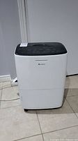 Front view of white Gree dehumidifier showing control panel and overall condition