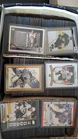Open storage box filled with rows of hockey cards; several top-loaded cards visible on top row