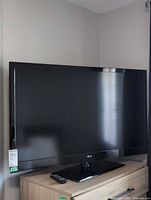 Front view of 46" LG TV on stand with remote