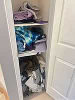 Shelves with folded towels, sheets and throw blanket visible