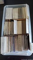 Plastic bin holding stacks of hockey cards separated by cardboard dividers
